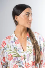 Bata kimono corta de algodón estampado con flores rojas, violetas y verdes. Tiene mangas al codo y lazo de ajuste en la cintura.