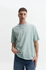 Remera de manga corta color marrón claro, de corte amplio y cuello redondo.