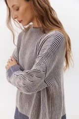 Sweater azul con diseño de trenzas verticales y horizontales.