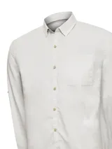 Camisa de manga larga color gris claro, confeccionada en algodón orgánico. Cuenta con cuello abotonado, cierre frontal con botones de madera, bolsillo en el pecho con logo bordado y mangas ajustables con botón.