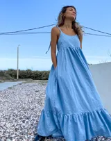 Maxi vestido celeste de jean con breteles regulables y bolsillos laterales.