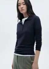 Polo gris de tejido de punto con cuello clásico, cierre de botones y mangas largas.