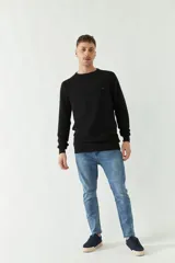 Sweater mostaza de punto con cuello redondo, mangas largas y logo bordado en el pecho. Corte slim fit.