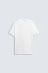 Jersey de punto blanco, corte relajado, con cuello redondo y manga corta.