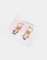 Aros dorados tipo argolla con dijes colgantes de cadenas, hojas y cuentas de colores.