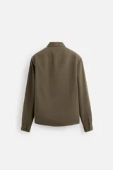 Camisa color crudo de algodón con acabado cepillado, corte relaxed fit, cuello solapa, manga larga con puño abotonado, bolsillo de parche en el pecho, efecto lavado y cierre frontal abotonado.