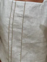 Musculosa blanca de lino con escote cuadrado y detalle de pespuntes verticales en el frente.