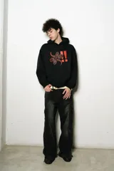 Hoodie oversize negro de algodón con estampa roja en el frente.