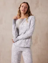 Conjunto de pijama estampado marca René Rofé, compuesto por pantalón largo y remera de mangas largas con puños. El pantalón tiene cintura elastizada con lazo de ajuste.