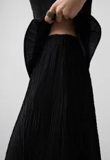 Pantalón palazzo negro con textura crinkle, cintura elástica, godets centrales y pierna ancha.