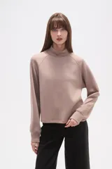 Buzo negro de manga larga con cuello tortuga y corte holgado.