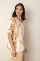 Blusa italiana color natural con estampado de hojas en tonos azules. De calce holgado y talle único.
