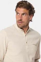 Camisa blanca de lino con cuello mao, medio abotonada, manga larga y corte slim.