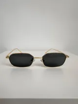 Lentes de sol con armazón metálico dorado y lentes rectangulares color negro.