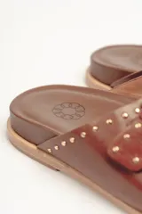 Sandalias marrones de cuero vacuno con doble tira y hebillas metálicas ajustables.