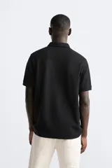Polo verde oliva de tejido piqué, corte regular fit, cuello solapa con cierre frontal de botonadura y manga corta.