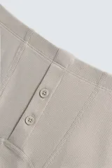 Conjunto de pijama color gris compuesto por una camiseta sin mangas de corte ajustado y un bóxer corto con cintura elástica y botones.