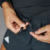 Short de running negro con cintura elástica y cordón ajustable, malla interna, bolsillo interno y aberturas laterales.