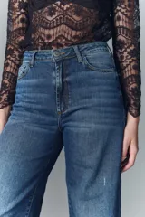 Pantalón jean de corte oxford confeccionado en denim confort con elastano, tiro alto, lavado azul con desgaste localizado y bigotes.