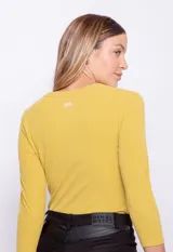 Remera color mostaza de manga larga con nudo en la parte frontal y textura acanalada.