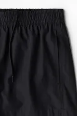 Short de baño negro con elástico revestido y cordón para ajustar oculto en la cintura, bolsillos laterales y abertura corta en los lados. Suspensor interior de malla.