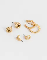 Set de tres pares de aros dorados con cierre a presión. Incluye un par de aros tipo botón con detalle de strass, un par de aros tipo botón con diseño de nudo y un par de aros tipo argolla texturizada.