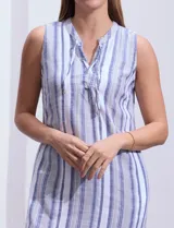 Vestido de algodón a rayas verticales azules y blancas, sin mangas, con cuello a la base y abertura central con lazo de ajuste.