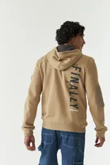 Campera de felpa color beige con capucha y cordón ajustable, cierre frontal, bolsillos con cierre, lettering estampado en la espalda y logo en grifa de goma.