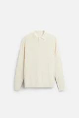 Polo relaxed fit de punto tejido en hilatura de algodón color crema. Cuello solapa con cierre frontal de botonadura. Manga larga y acabados en rib.