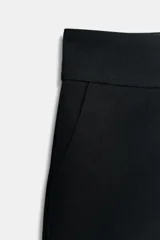 Shorts de tiro medio color negro, con bolsillos delanteros y falsos bolsillos con solapa en la parte trasera. Cierre frontal con cremallera y ganchos metálicos.