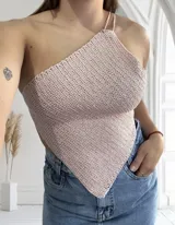 Top tejido al crochet color rosa pálido, con diseño asimétrico de un solo hombro y tirantes finos.