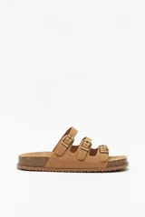 Sandalias color marrón con base de corcho y triple tira ajustable de gamuza y hebillas metálicas.