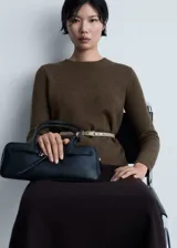 Sweater color crema de tejido de punto grueso con cuello redondo y mangas largas.