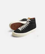 Championes de caña alta de lona negra con cordones blancos y suela de goma color crema.