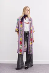 Kimono largo hasta la rodilla, de mangas 3/4 y calce amplio con tajos laterales. Diseño estampado con motivos florales y guardas.