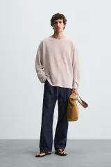 Jersey color verde claro de punto tejido en hilatura ligera de lino, corte relaxed fit, cuello redondo y manga larga con terminaciones en rib.