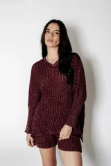 Conjunto de sweater y short de punto color borgoña con lurex. El sweater es de corte holgado con cuello en V y mangas largas. El short es de corte holgado con cintura elástica.