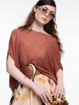 Top de punto color marrón con lurex, de silueta amplia, manga caída y escote redondo.