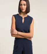Blusa musculosa azul marino de crepé con cuello redondo y escote en V con aro metálico.