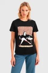 Remera negra con estampado de una mujer sentada en un sillón con un trago en la mano.