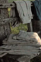 Pantalón de vestir color beige con estampado a cuadros en tonos marrones, verdes y rojos.