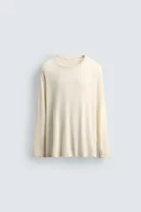 Camiseta color crema de viscosa y lino, corte relaxed fit, cuello redondo y manga larga.