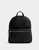 Mochila negra de cuerina con correas regulables, manija superior, cierre superior con doble deslizador, bolsillo frontal con cierre y deslizador, etiqueta metálica y bolsillos laterales.