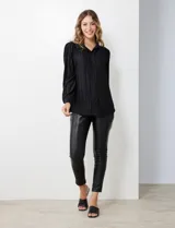 Camisa negra de satén plisado con cuello con solapa y abertura central con botones.