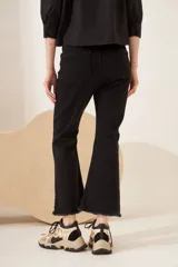 Jean flare elastizado negro con ruedo desflecado y ajuste cómodo.
