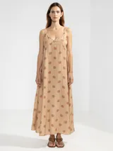 Vestido largo hasta el tobillo de viscosa y poliamida, con estampado de rayas verticales rosas y flores rojas. Tiene breteles finos, escote en V profundo y detalle de flor Polonio en cobre.