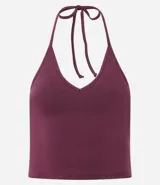 Top cropped de algodón color amarillo pálido, con escote en V pronunciado y tirantes finos que se atan en la nuca (estilo halter). El tejido es acanalado.