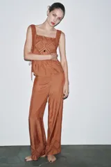 Top marrón con escote cuadrado, tirantes anchos y detalle de puntilla y bordados en forma de rombos. Aberturas laterales ajustables con lazadas.