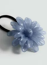 Coletero con elástico negro y aplique de flor color crema.