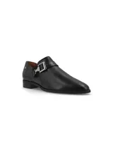 Zapato de cuero color marrón con hebilla metálica lateral y elásticos texturados.